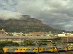 Die Metrorail bei der Einfahrt in den Hauptbahnhof, im Hintergrund der Tafelberg